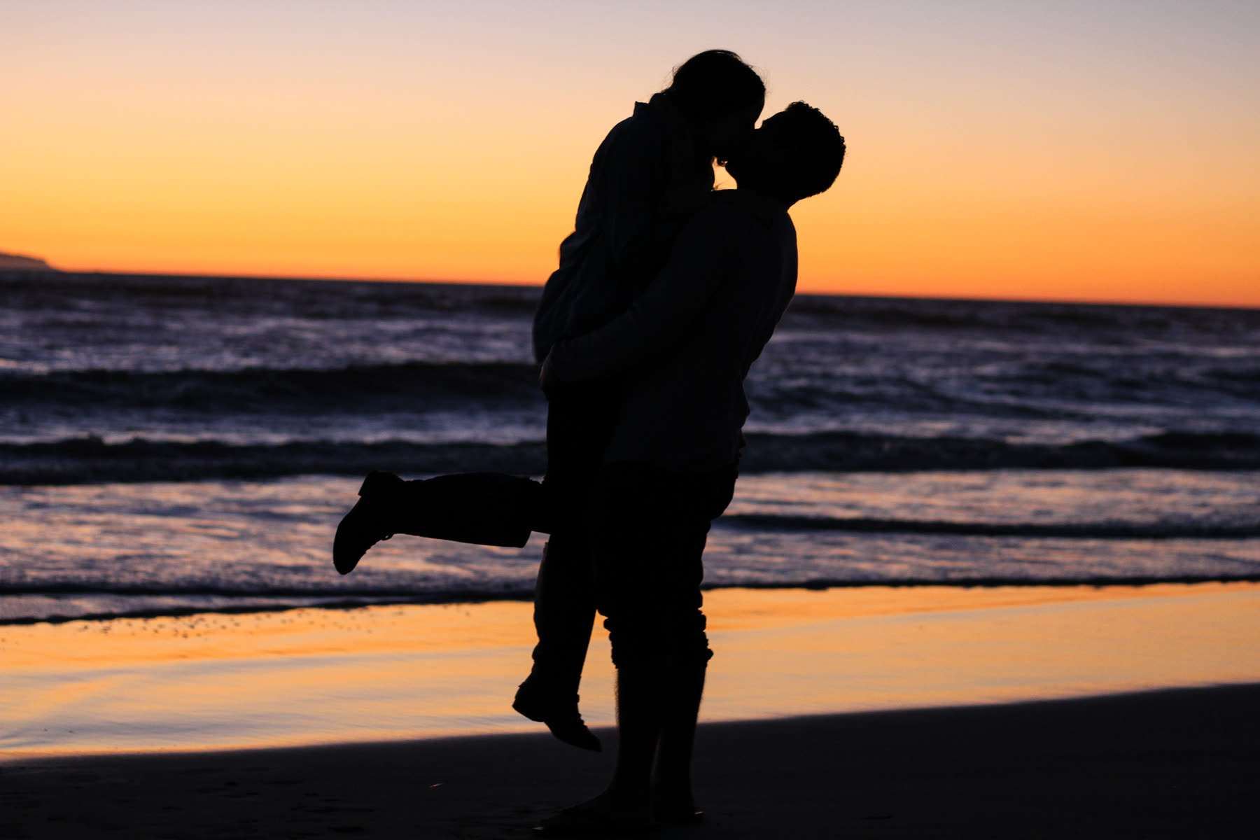 Couple enlacé face à la mer au crépuscule